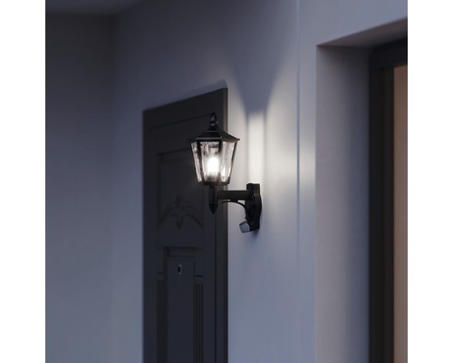 Lumină de perete exterioară aprinsă cu senzor de mișcare lângă o ușă