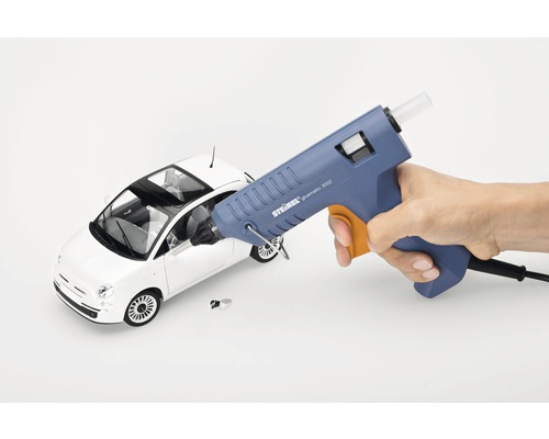 Pistol de lipit cu silicon care lipește o mașină de jucărie