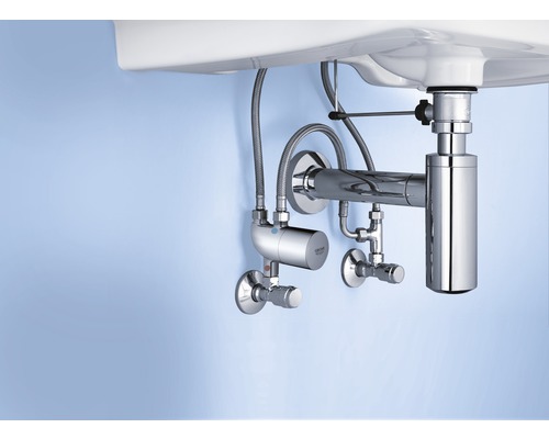 Vedere de dedesubt a unei chiuvete cu sifon și robinete de colț