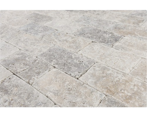 Plăci dreptunghiulare de travertin așezate în model herringbone