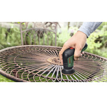 Perie de sârmă folosită pe o masă de grădină din metal