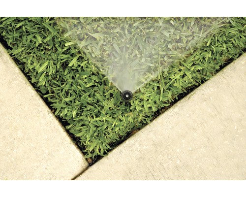 Sistem de irigare pe gazon lângă plăci de beton