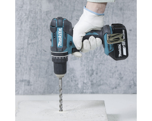 Mașină de găurit și înșurubat cu impact cu acumulator Makita cu burghiu în utilizare.