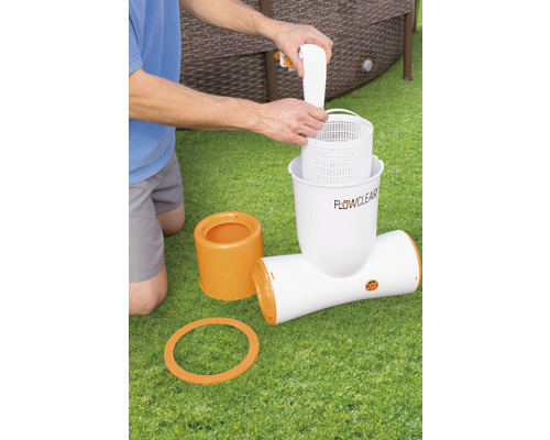 Bărbat care introduce un element de filtru de piscină într-o pompă de filtru de piscină.