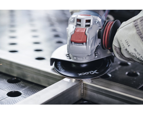 O persoană folosește un polizor unghiular pentru a șlefui o bucată de metal.