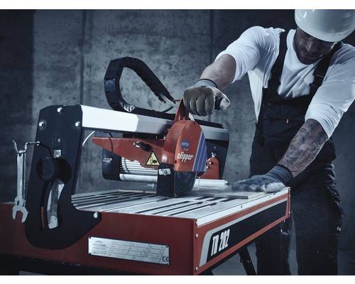 Mașină de tăiat faianță în acțiune cu muncitor în construcții