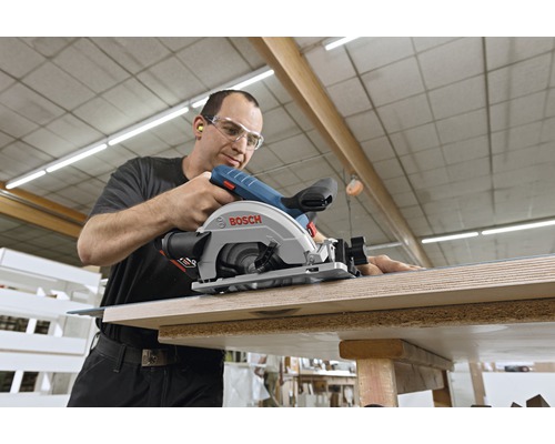 Un bărbat folosește un fierăstrău circular portabil Bosch pentru a tăia lemn.