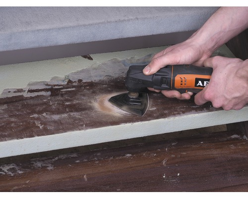 O persoană folosește un instrument multifuncțional pentru a șlefui o suprafață din lemn. Logo AEG.