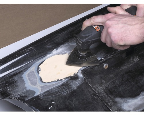 Unealtă electrică oscilantă utilizată pe o suprafață cu chit.