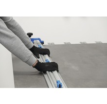 Persoană care folosește un tăietor de plăci pentru a tăia plăci