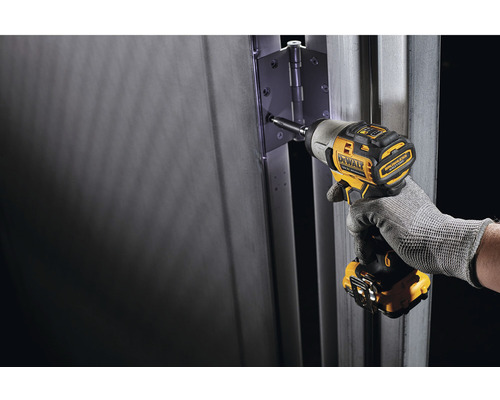 O șurubelniță cu impact fără fir marca DeWalt este folosită pentru a fixa o balama de ușă pe o ușă.