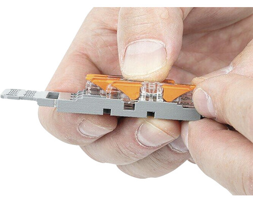 Un bărbat apasă o manetă pe un set de borne de conectare.