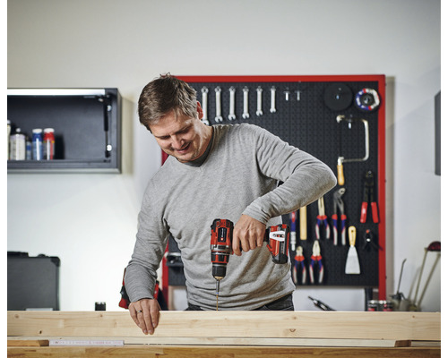 Bărbat care lucrează cu o șurubelniță fără fir pe lemn într-un atelier