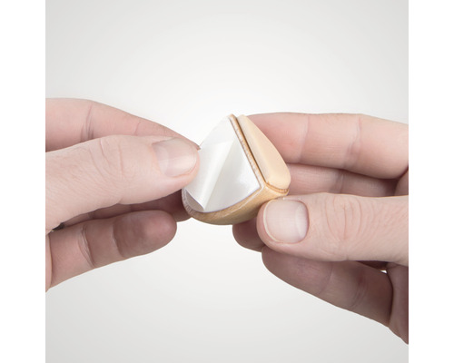 Mâini care îndepărtează folia de protecție de pe un glisor de mobilă