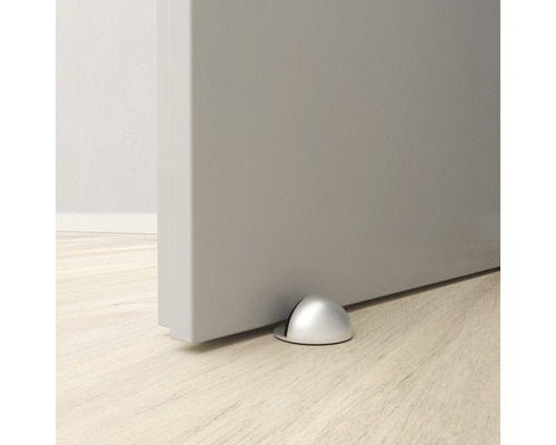 Oprire de ușă metalică pe podea în fața unei uși