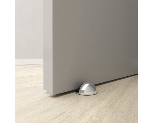 Opriitor de ușă metalic pe podea în fața unei uși