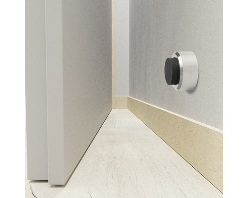 Opriitor de ușă de perete din metal cu tampon de cauciuc lângă o ușă