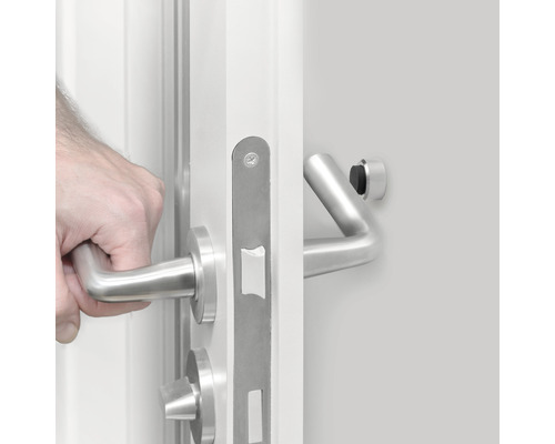 Mână deschizând o ușă albă cu feronerie din oțel inoxidabil