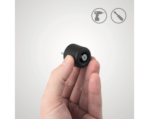 O mână ține un opritor negru de ușă pentru montare cu șurub. Simboluri de instalare în fundal.