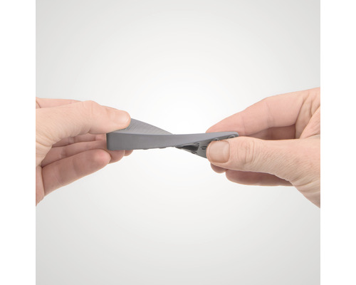 O persoană îndoaie un opritor de ușă din cauciuc.