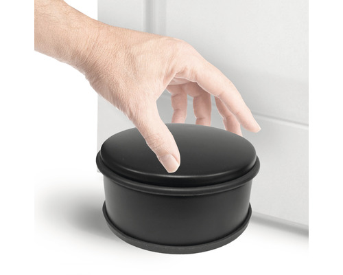 Opriitor de ușă rotund negru lângă o ușă cu o mână pe el