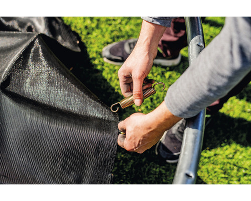 O persoană fixează un arc de tracțiune de o trambulină