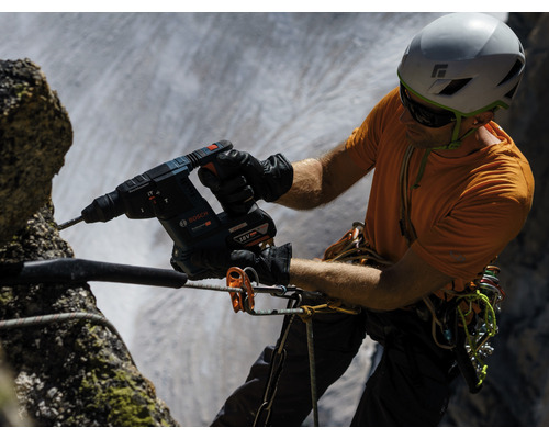Artizanul forează o gaură într-o stâncă cu un ciocan rotopercutor Bosch.