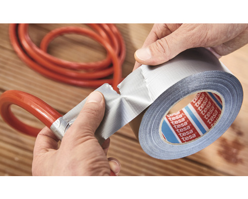 Utilizatorul repară furtunul cu rolă de bandă adezivă Tesa