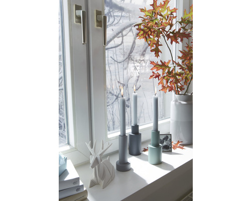 Scenă decorativă cu suporturi pentru lumânări, lumânări, fereastră, figurină de cerb și frunze de toamnă