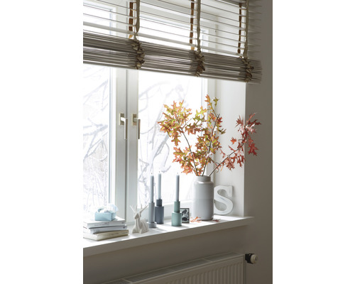 Decorațiune de fereastră cu jaluzele, vază cu ramuri, lumânări și obiecte decorative pe pervazul ferestrei