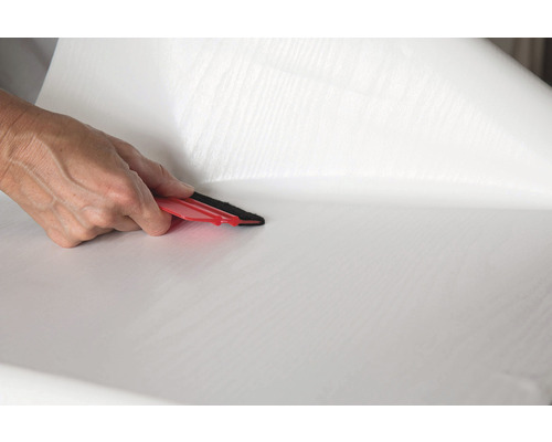 Aplicarea unei folii adezive albe cu o racletă