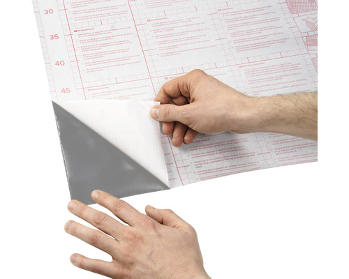 O persoană îndepărtează folia de protecție de pe o folie autoadezivă