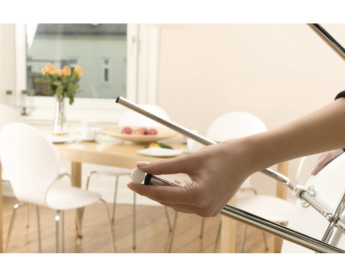 O persoană ține un suport de mobilier care este atașat de un scaun pentru a proteja podelele.