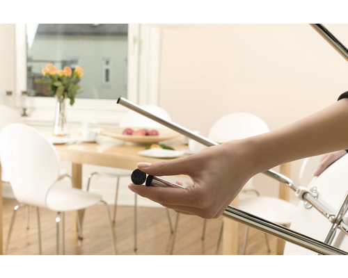 Femeie atașează un glisor din pâslă la piciorul unui scaun