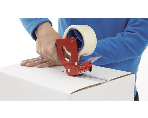 O persoană sigilează o cutie de carton cu un derulator manual și bandă adezivă.