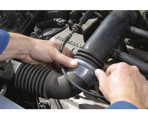 Repararea unui furtun deteriorat în compartimentul motor cu bandă adezivă.
