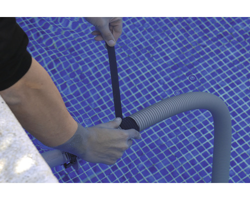 Persoană care fixează un furtun de piscină cu o bandă