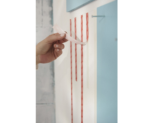 Banda adezivă dublă este dezlipită de o mână