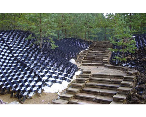 Consolidare taluz cu geocelule și scară de piatră într-o grădină.