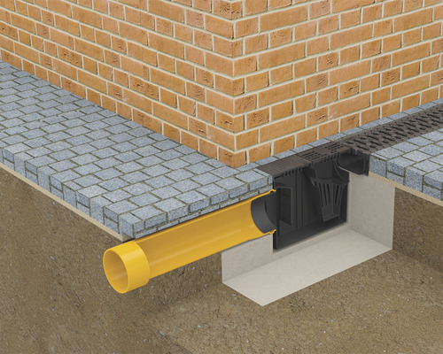 Prim-plan cu o instalație de scurgere de curte cu rigolă de drenaj, conductă și zidărie de cărămidă
