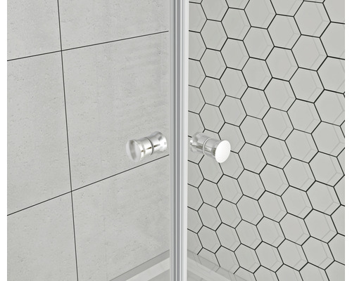 Prim-plan cu o cabină de duș cu pereți de sticlă și mânere pe fundal de plăci hexagonale