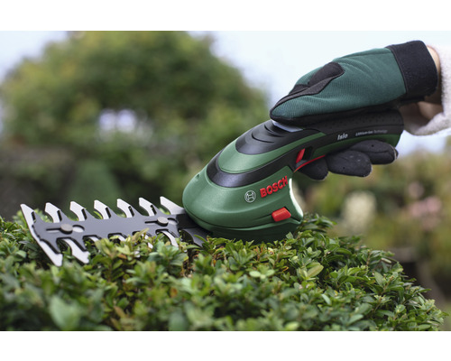 Sigla Bosch. Foarfece de gard viu cu acumulator, utilizat pe un gard viu.