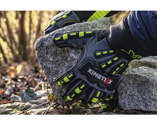 O pereche de mănuși de lucru gri KinetiXx țin o piatră