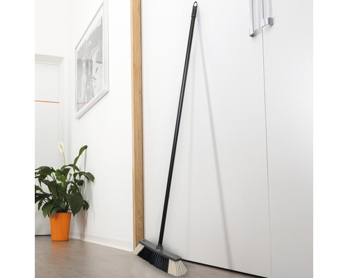 Mătură cu coadă, sprijinită de o ușă