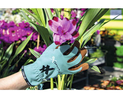 Mână cu mănușă de grădinărit KinetiXx ținând o floare roz
