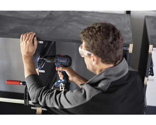 Artizan care lucrează cu o șurubelniță cu acumulator la o piesă de mobilier