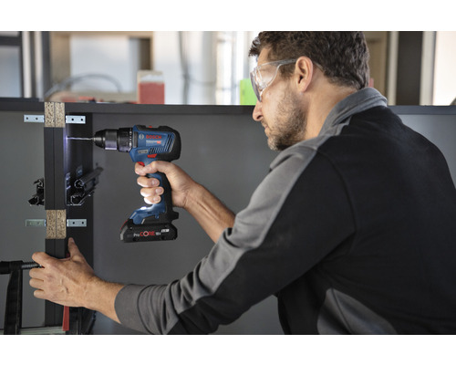 Un bărbat găurește o piesă de lucru cu o șurubelniță cu acumulator Bosch.