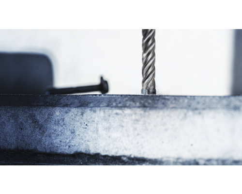 Prim-plan cu un burghiu care găurește o piesă de lucru