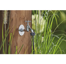 Robinet de grădină cu robinet de apă și racord de furtun pe un perete de lemn