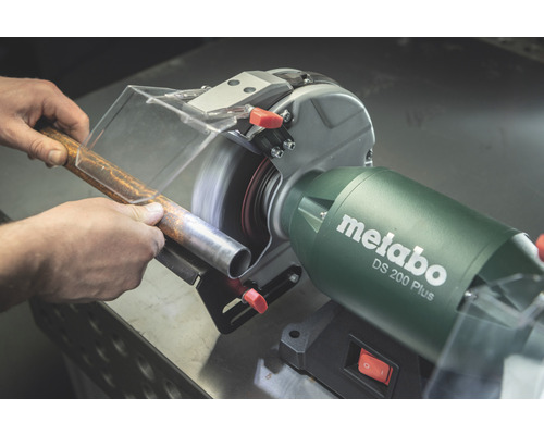 Polizor de banc Metabo șlefuind o țeavă metalică